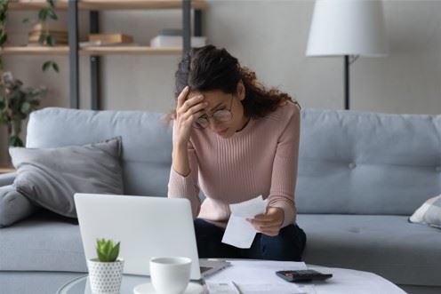stressed woman looking at pile of receipts