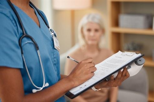 Doctor Writing On Patient Medical Files