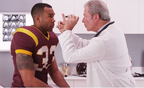 football player being examined for concussion by doctor