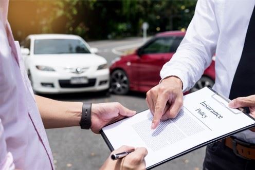 insurance adjuster speaking with man about car insurance policy